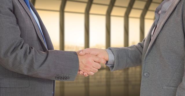 Use this image showcasing a professional handshake between businessmen to convey themes of partnership, trust, and successful business dealings. Ideal for websites, presentations, and marketing materials focused on business success, networking, agreements, and teamwork.