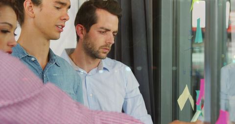 Diverse Team Creating Strategies with Sticky Notes in Office Meeting