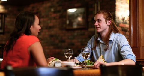 Young Couple Dining in Cozy Restaurant Engaged Enjoying Conversation
