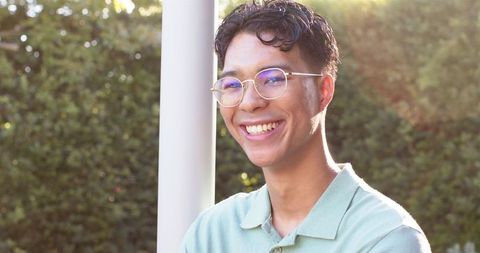 Young Man in Glasses Enjoying Sunlight Outdoors