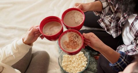 Diverse Friends Enjoying Cozy Time with Hot Drinks and Popcorn