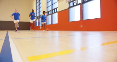 Energetic Group of Girls Playing Basketball in Gym
