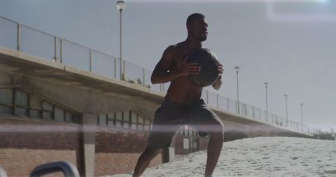 Man Exercising at Beach with Medicine Ball