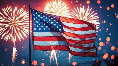 American flag waving at night with bright fireworks display
