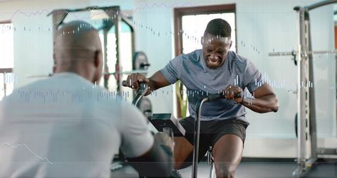 Pushing through intense air bike sprints with trainer encouraging