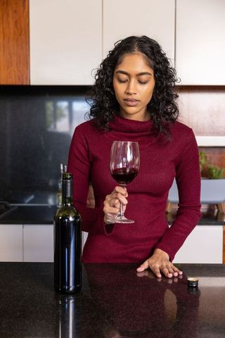 Woman in Elegant Kitchen Enjoying Red Wine Experience