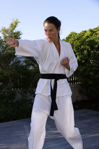 Female Karate Black Belt Executing Punch on Outdoor Deck
