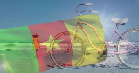 Pink cruiser bicycle resting on sandy beach with cameroon flag overlay and woman walking