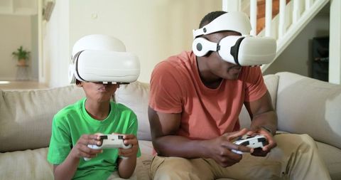 African American Father and Son Playing VR Games on Couch at Home, Virtual Reality Fun
