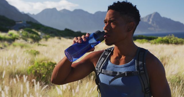 African american man exercising outdoors drinking water in countryside on a coast - Download Free Stock Photos Pikwizard.com