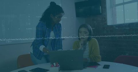 Two Colleagues Collaborating at Laptop in Modern Industrial Meeting Room with Whiteboard