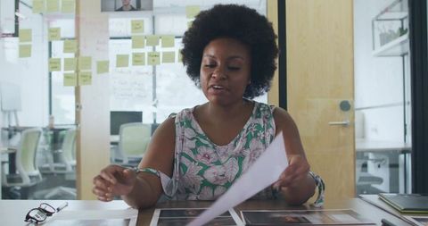 Designer Reviewing Creative Prints in Modern Office