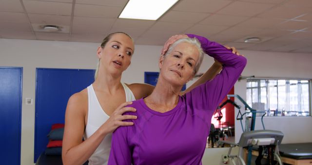 Young Physiotherapist Assisting Senior Woman with Neck Stretch in Clinic - Download Free Stock Images Pikwizard.com