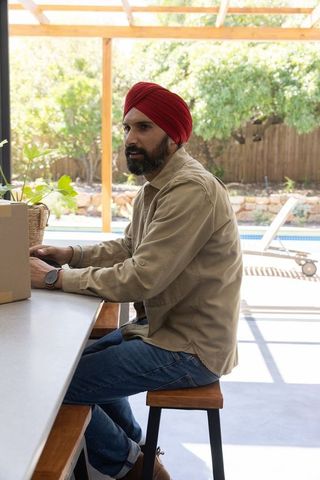 Indian man with turban enjoying outdoor workspace serenity with box and planter