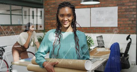 Smiling Businesswoman Holding Cardboard Rolls with Digital Graph Overlays