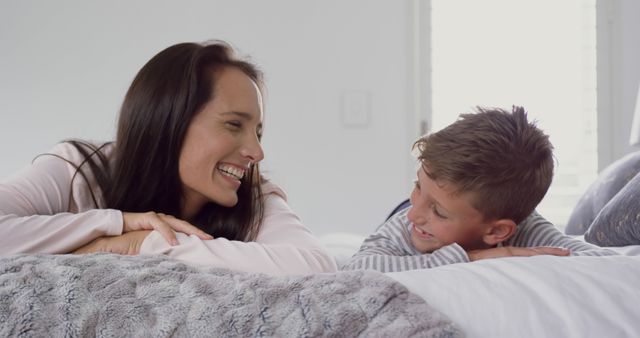 Happy Mother and Son Laughing Together in Bedroom - Download Free Stock Images Pikwizard.com