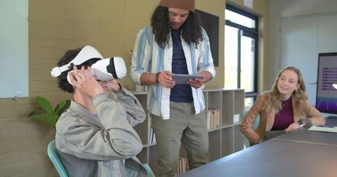 Diverse team testing vr headset during modern office meeting for tech collaboration
