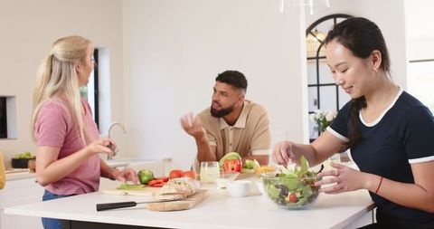 Diverse friends cooking together with fresh ingredients