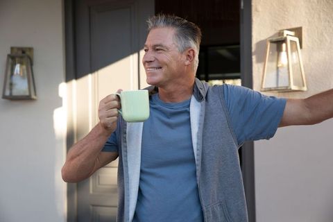 Mature man enjoying morning coffee on porch