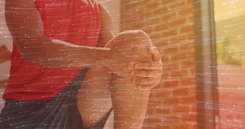 Man Stretching in Home Gym With Sunlit Brick Background