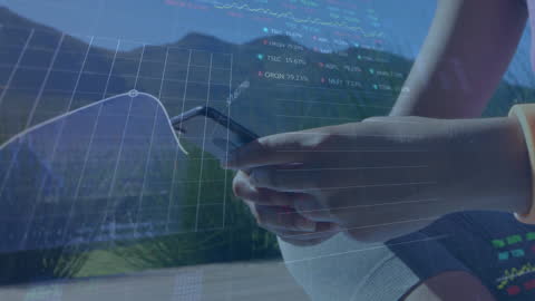 Hand Holding Smartphone with Financial Data Overlays Outdoors
