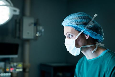 Surgeon in Hospital Wearing Mask Focused During Surgical Procedure