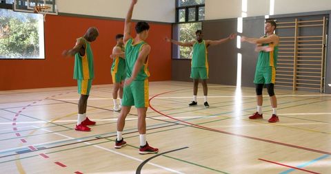 Young Male Basketball Team Warming Up Indoors in Jerseys