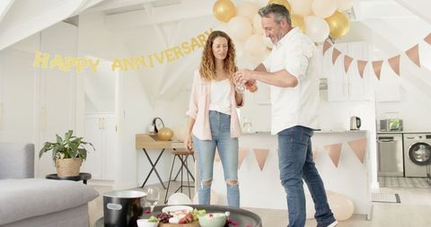 Mature Couple Celebrating Anniversary with Wine and Snacks