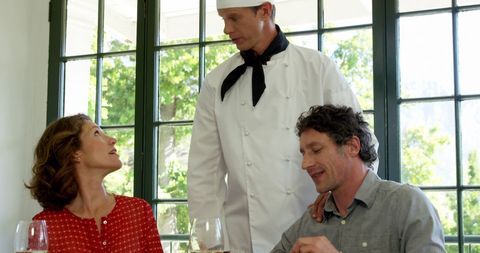 Restaurant Chef Conversing with Guests by Window