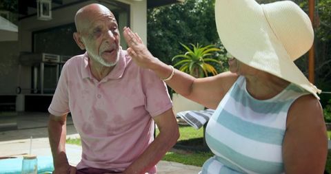 Senior couple relaxing together in backyard on a sunny day