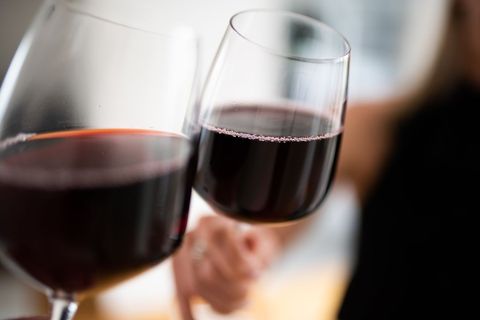 Close-Up of Hands Clinking Red Wine Glasses Celebrating