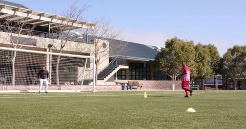 Boys practicing soccer dribbling skills on school field