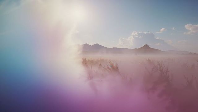 Ethereal misty plain with distant mountain view at sunrise