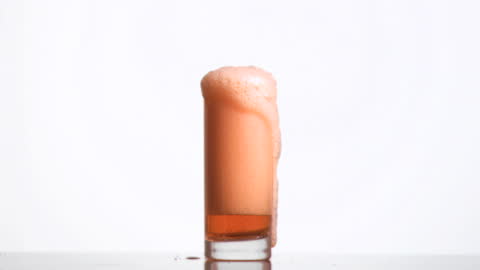 Overflowing Amber Beverage Bubbling in Slow Motion