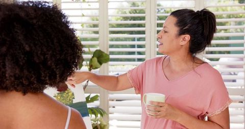 Woman Discussing Art While Relaxing With Friend Indoors