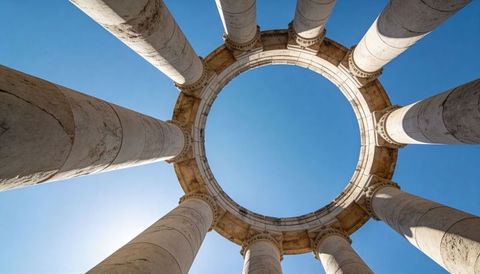 Framing circular colonnade with oculus and towering stone columns against clear blue sky