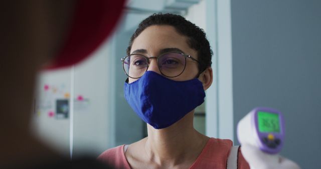 Woman Wearing Mask Getting Temperature Checked with Forehead Thermometer - Download Free Stock Images Pikwizard.com