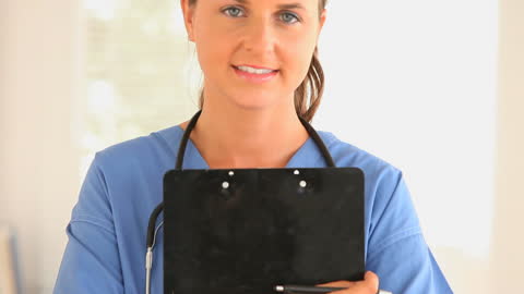 Smiling Doctor Holding Clipboard with Stethoscope and Uniform