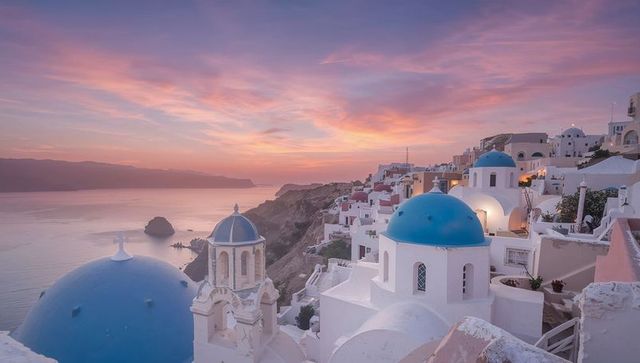 Santorini's Iconic Blue Domed Rooftops at Sunset