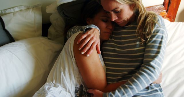 Comforting embrace between two women on bed - Download Free Stock Images Pikwizard.com