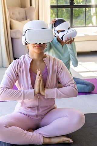 Diverse women practicing vr-guided yoga at home wearing pastel mint activewear