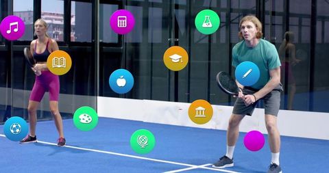 Couple using ar icons while playing padel on blue indoor court with glass reflections