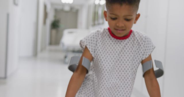 African american male doctor walking with child patient using crutches at hospital - Download Free Stock Photos Pikwizard.com