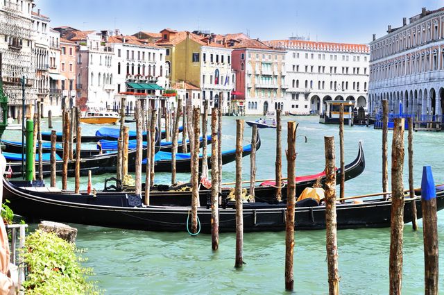 Gondolas floating on Grand Canal in Venice, Italy, surrounded by historic buildings showcasing typical Venetian architecture. Ideal for use in content about travel destinations, European landmarks, Venetian culture, cityscapes, and romantic getaways.