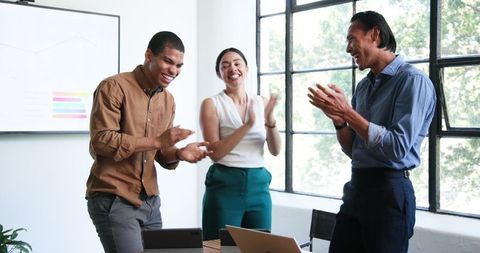 Diverse Colleagues Celebrating Successful Meeting in Bright Office