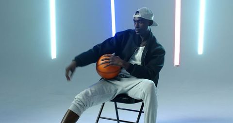 Athletic Man Holding Basketball Under LED Lights
