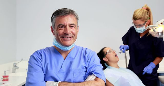 Confident Male Dentist with Assistant Treating Female Patient in Dental Office - Download Free Stock Images Pikwizard.com