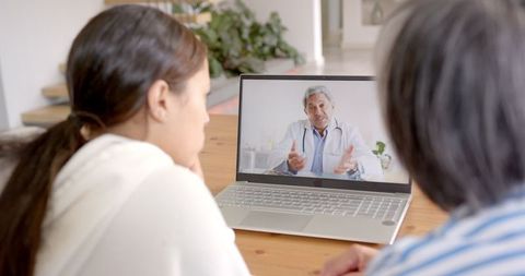 Biracial Woman and Elderly Woman Having Online Doctor Consultation