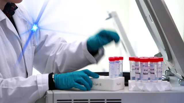 The scene shows a female scientist in a lab coat placing test tubes into a machine, indicating a sterile and advanced laboratory environment. This video can be ideal for illustrating medical research, scientific studies, biotechnology, laboratory processes, or health technology topics. It can be used in articles, presentations, websites, or advertisements related to medical science, laboratory work, or healthcare research.