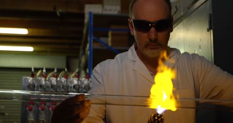 Glassblower Expertly Heating Glass Tube in Workshop